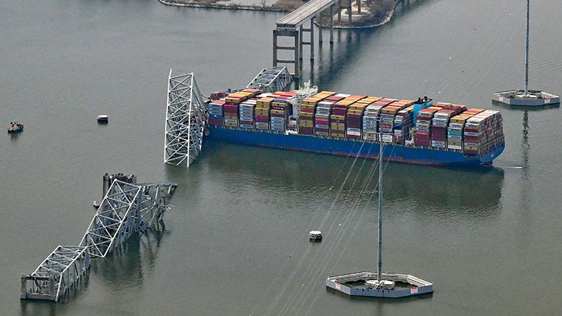 Baltimore a damaged containership rests next to a bridge pillar in the Patapsco River
