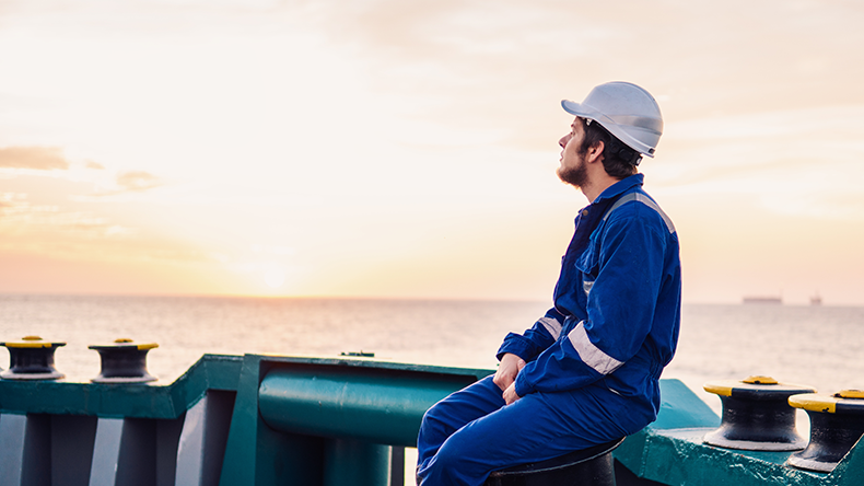 Marine Deck Officer or Chief mate on deck of offshore vessel or ship looking at sunrise