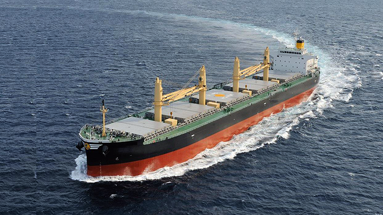 Dry bulk carrier at sea with white waves