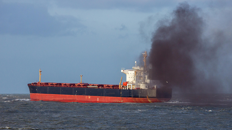 General cargoship causing air pollution with black smoke