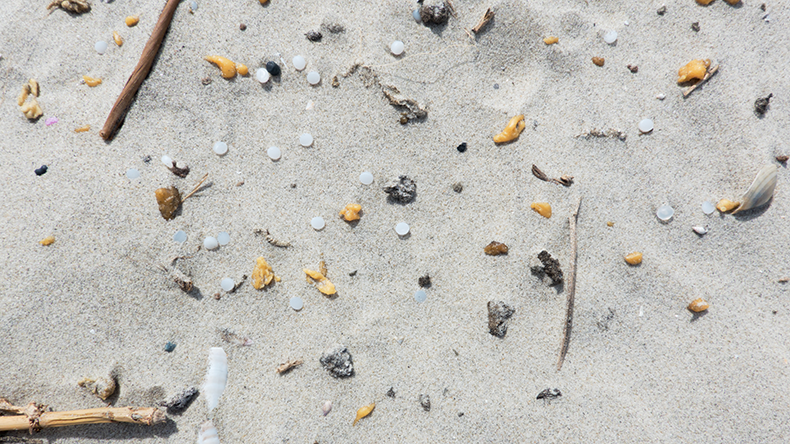 Pollution with microplastics, nurdles or small plastic granules, on the sand of the beach