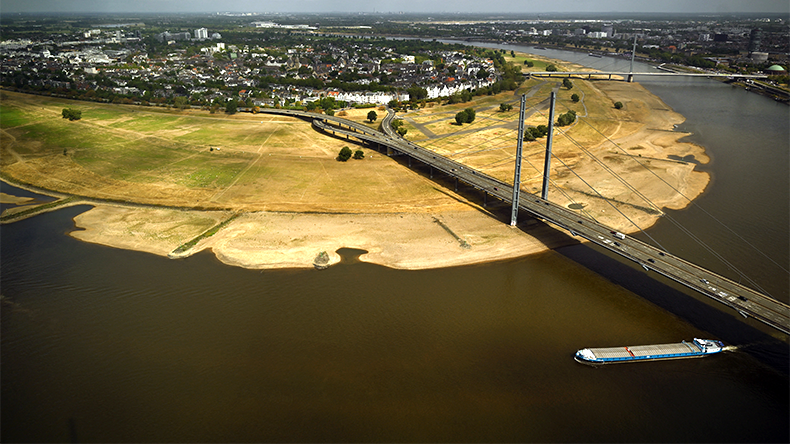 A vessel sails past the partially dried-up river bed of the Rhine in Dusseldorf, western Germany, on August 20, 2026, following exceptionally hot weather