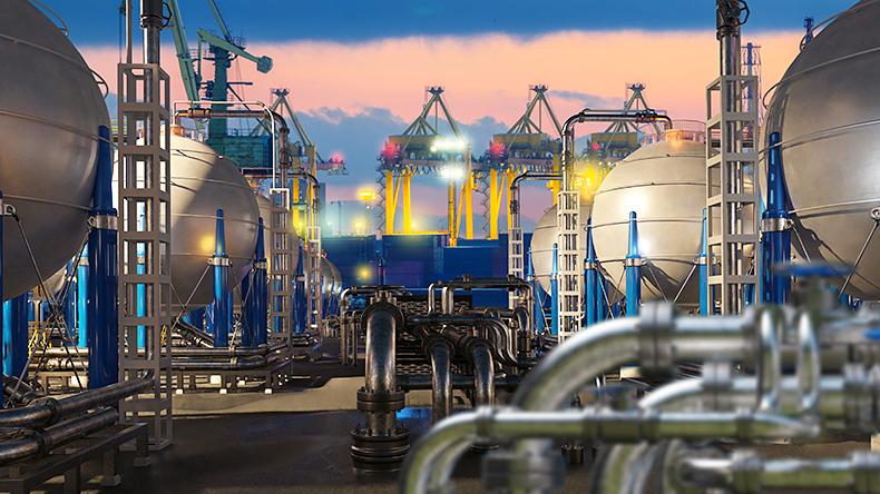 Liquefied natural gas terminal with spherical storage tanks, pipelines and cranes at port during sunset operations.