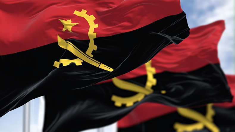 Close-up of Angola national flags waving in the wind on a clear day. Two horizontal bands, red and black, with a yellow emblem in the center