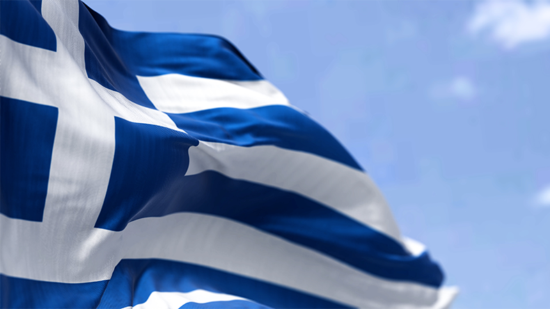 Greece or Greek flag blowing in the wind with a blue sky in the background