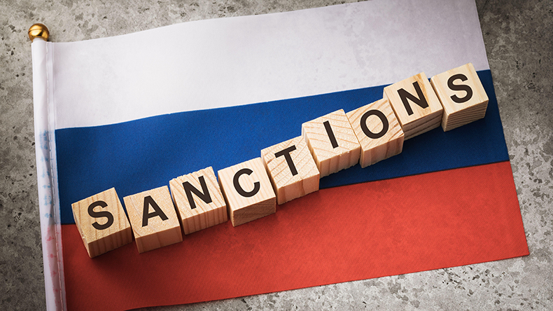  Wooden cubes with text and a flag on a concrete background, the concept of sanctions in Russia - Image ID: 2HHD5EH.  Credit: SERGEI CHAIKO / Alamy Stock Photo 
