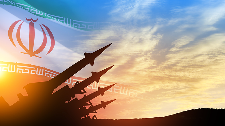 Missiles are aimed at the sky at sunset with Iran flag