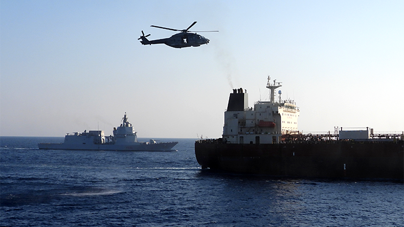 An Italian military helicopter flies above the oil tanker Toa Payoh, foreground, as the Italian Navy ship Thaon di Revel sails nearby during an inspection by the European Union’s EUNAVFOR MED Irini mission
