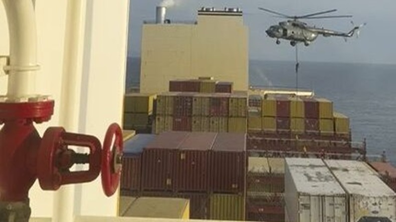 A helicopter hovers over containership MSC Aries as Iranian forces descended by rope one by one on to the deck.