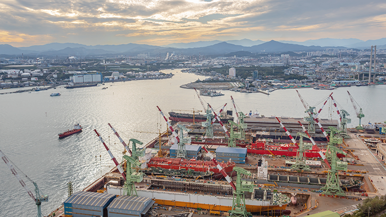 Futuristic shipyard with green technology and modern vessels.