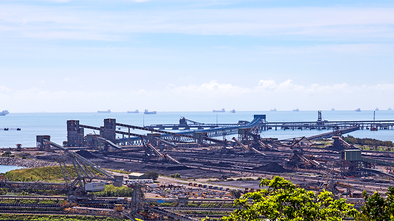 Gladstone port in Queensland, Australia with coal piles and ships in the distance taken at a public lookout