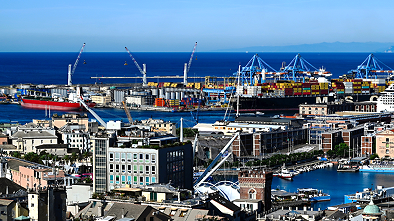 Aerial view of central Genoa old port area. rooftops and stucco facades. heavy duty harbor cranes at far