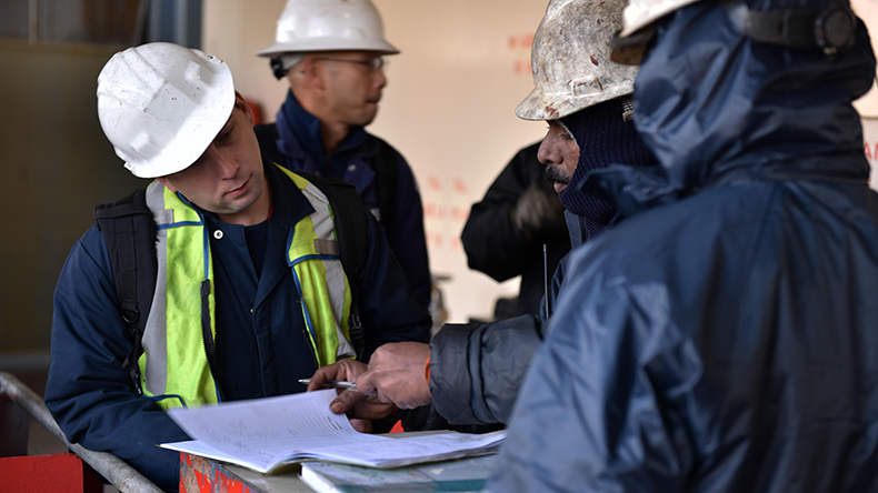 Marine investigators sign in with a crew member aboard a containership 