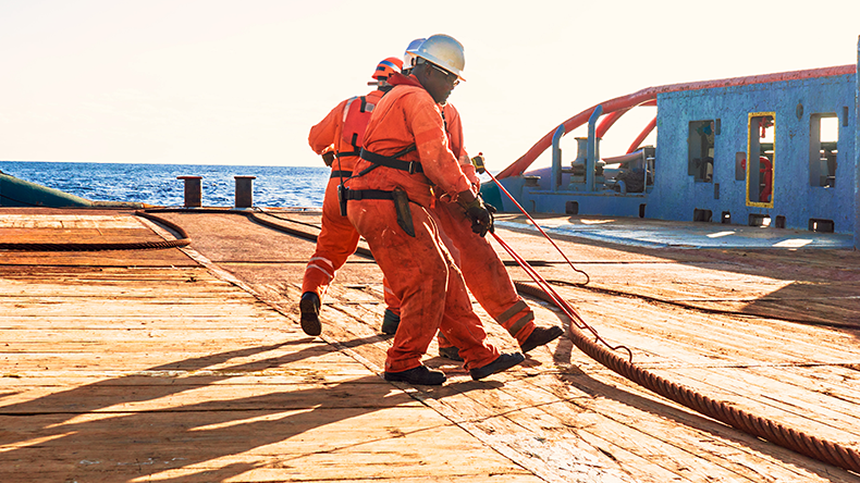 Anchor-handling Tug Supply AHTS vessel crew preparing vessel for static tow tanker lifting