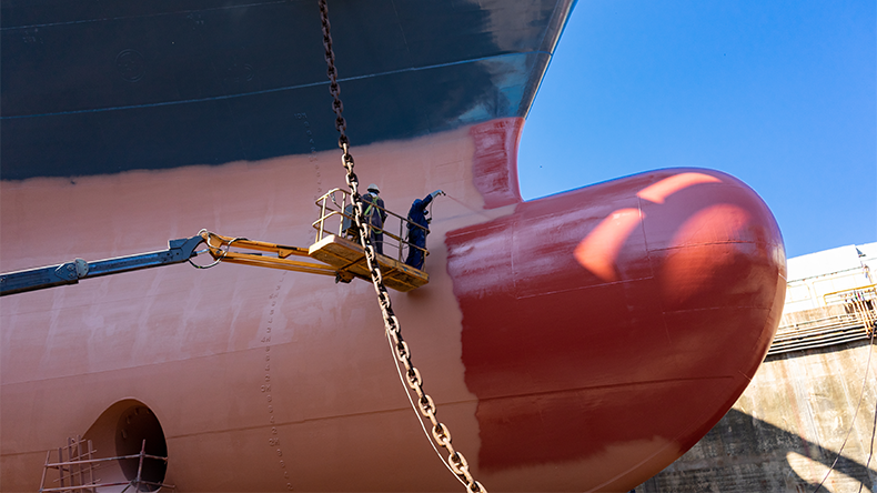 Painters painting a ship at a shipyard
