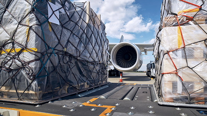Preparation before flight. Loading of cargo containers against jet engine of freight airplane