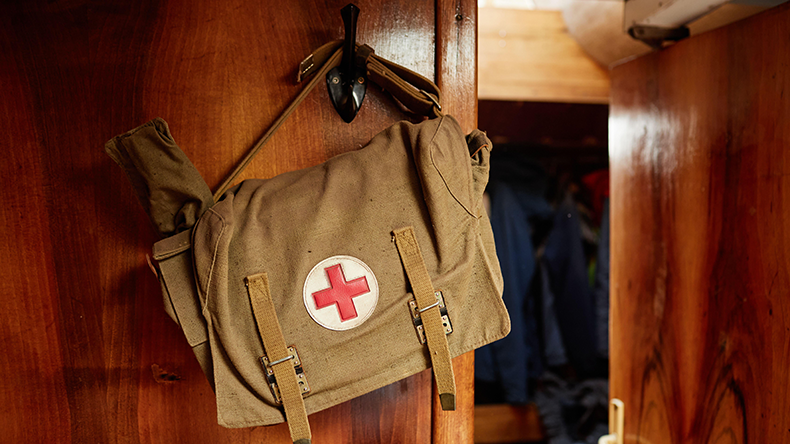First aid kit on wooden wall 