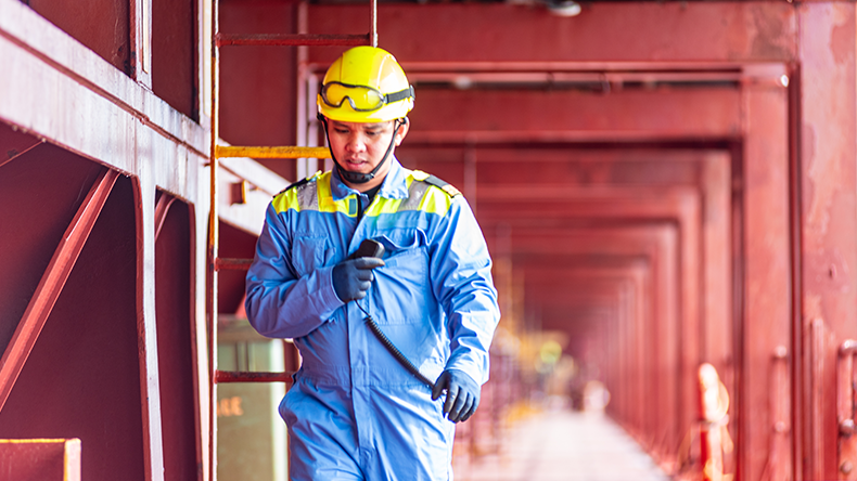 A deck officer of a merchant ship walking across the deck