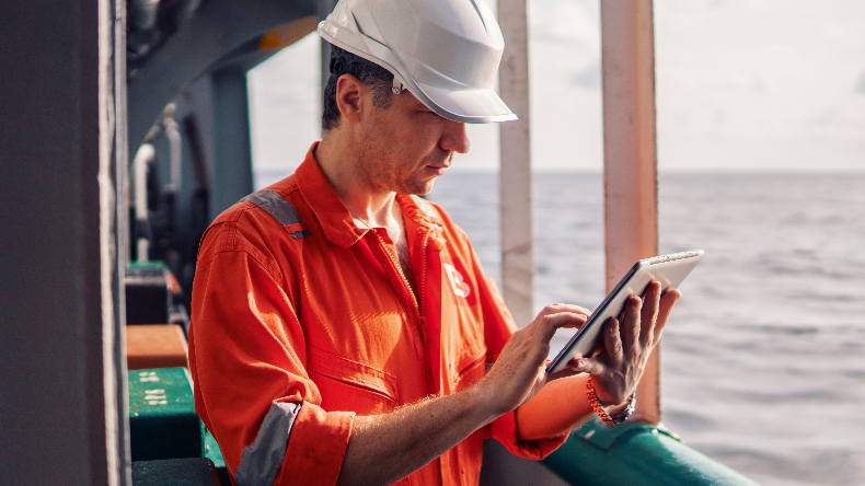Seafarer using digital technology or an iPad at sea