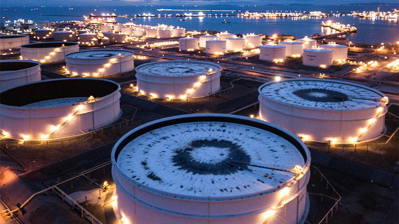 Aerial view of a bustling oil refinery and tank farm, showcasing a complex network of pipelines, storage tanks, and processing facilities