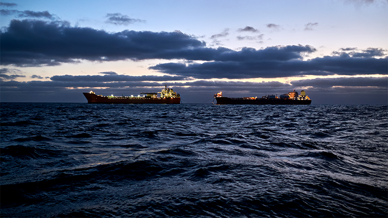 Cargo operations between fpso tanker and shuttle tanker in the sea, with dramatic sky