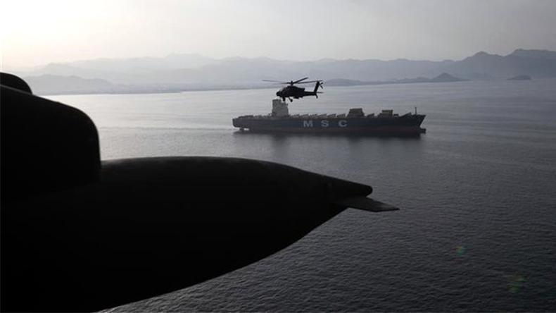 AH-64 Apaches fly above the Strait of Hormuz near MSC vessel