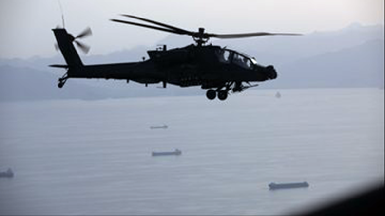 AH-64 Apaches fly above the Strait of Hormuz during a patrol