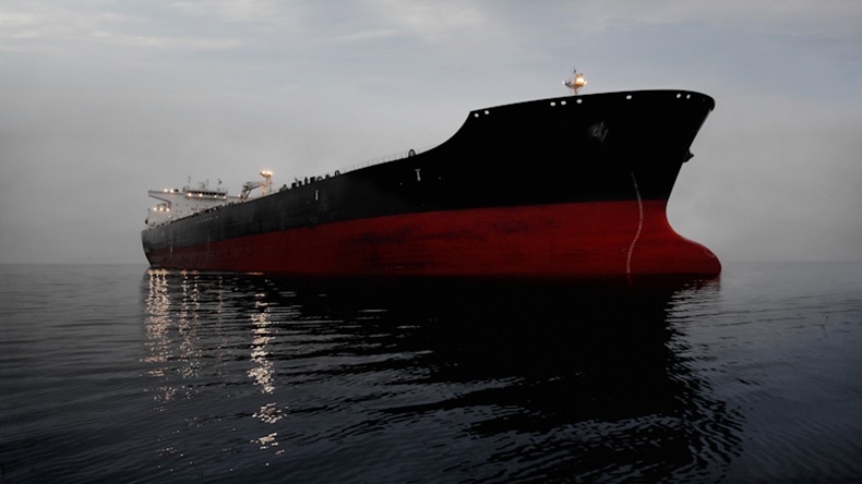 A 800,000 barrel oil tanker floating in quiet seas at twilight. The tanker is waiting for entry into Long Beach/Los Angeles harbor.